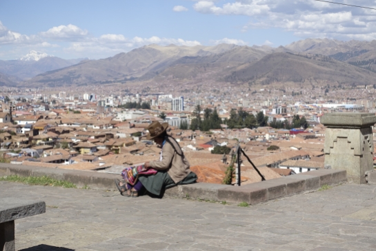 Peruvian woman doing her handcraft with view on Cusco
